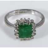 An 18ct white gold emerald and diamond cluster ring, size T