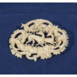 A carved ivory brooch with deer and foliage