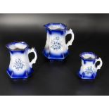 Three blue and white graduated jugs