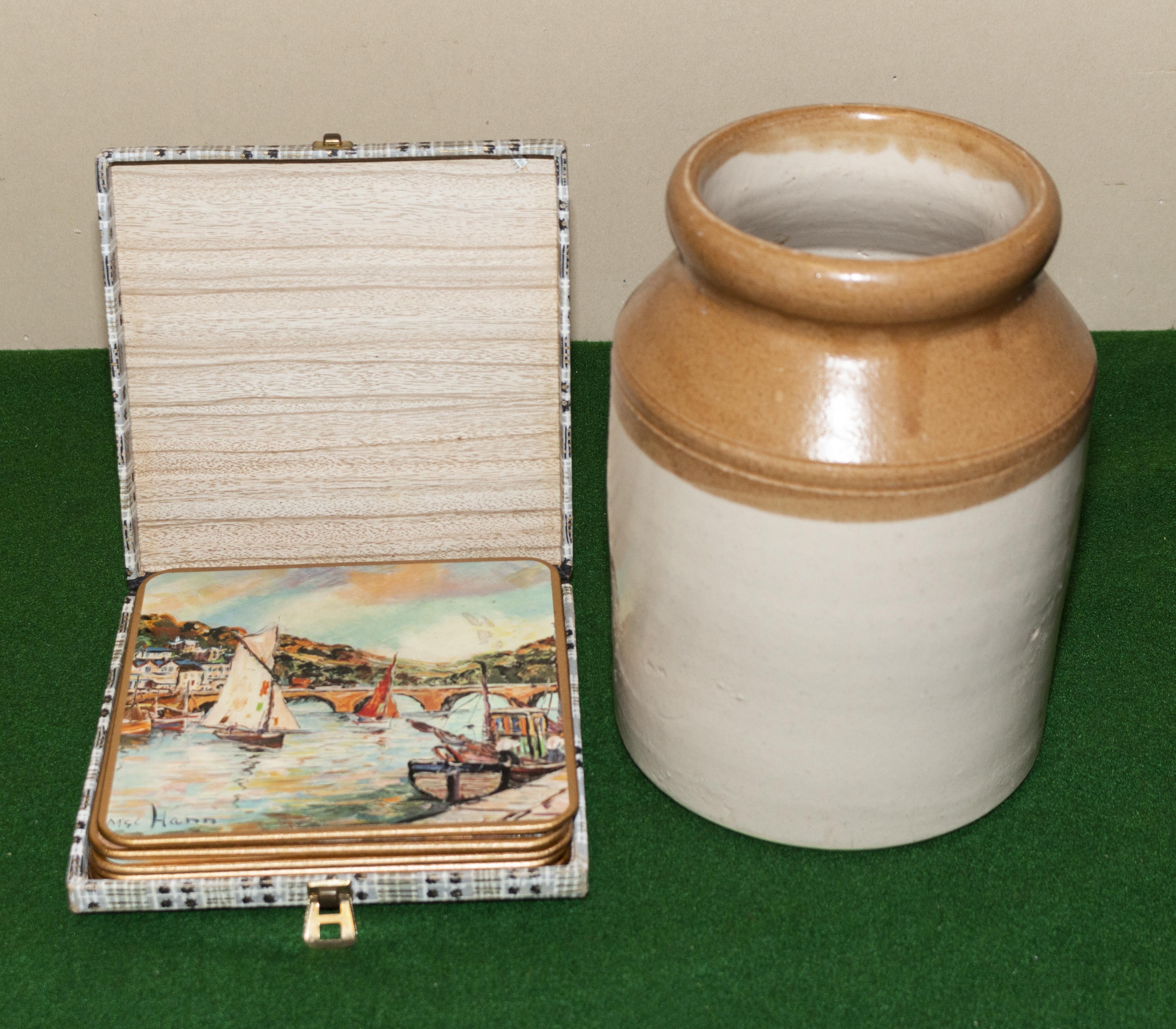 A stoneware jar and a box of vintage table mats