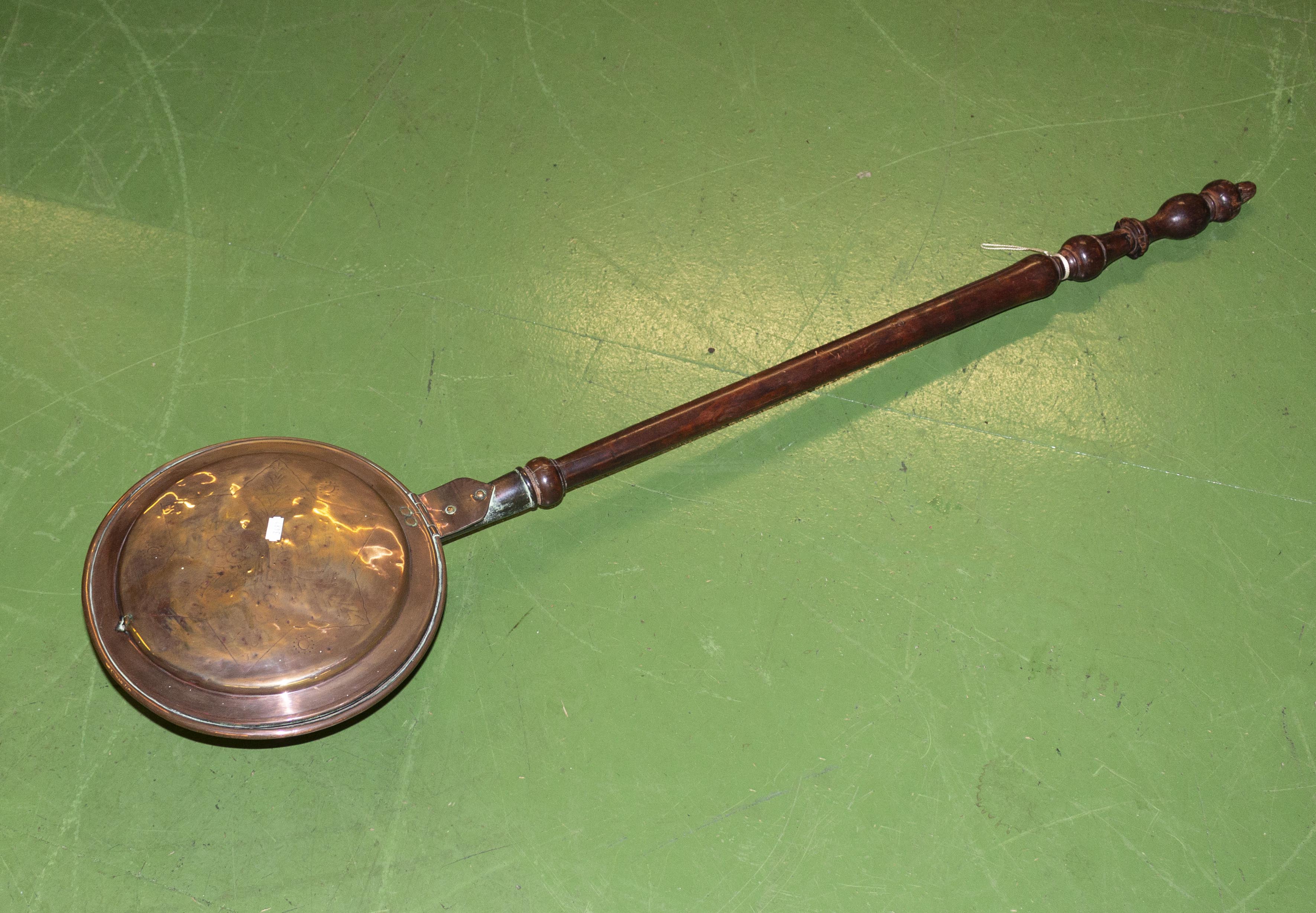 A copper bed warmer pan