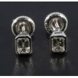 A pair of white gold emerald cut diamond studs, 63pt