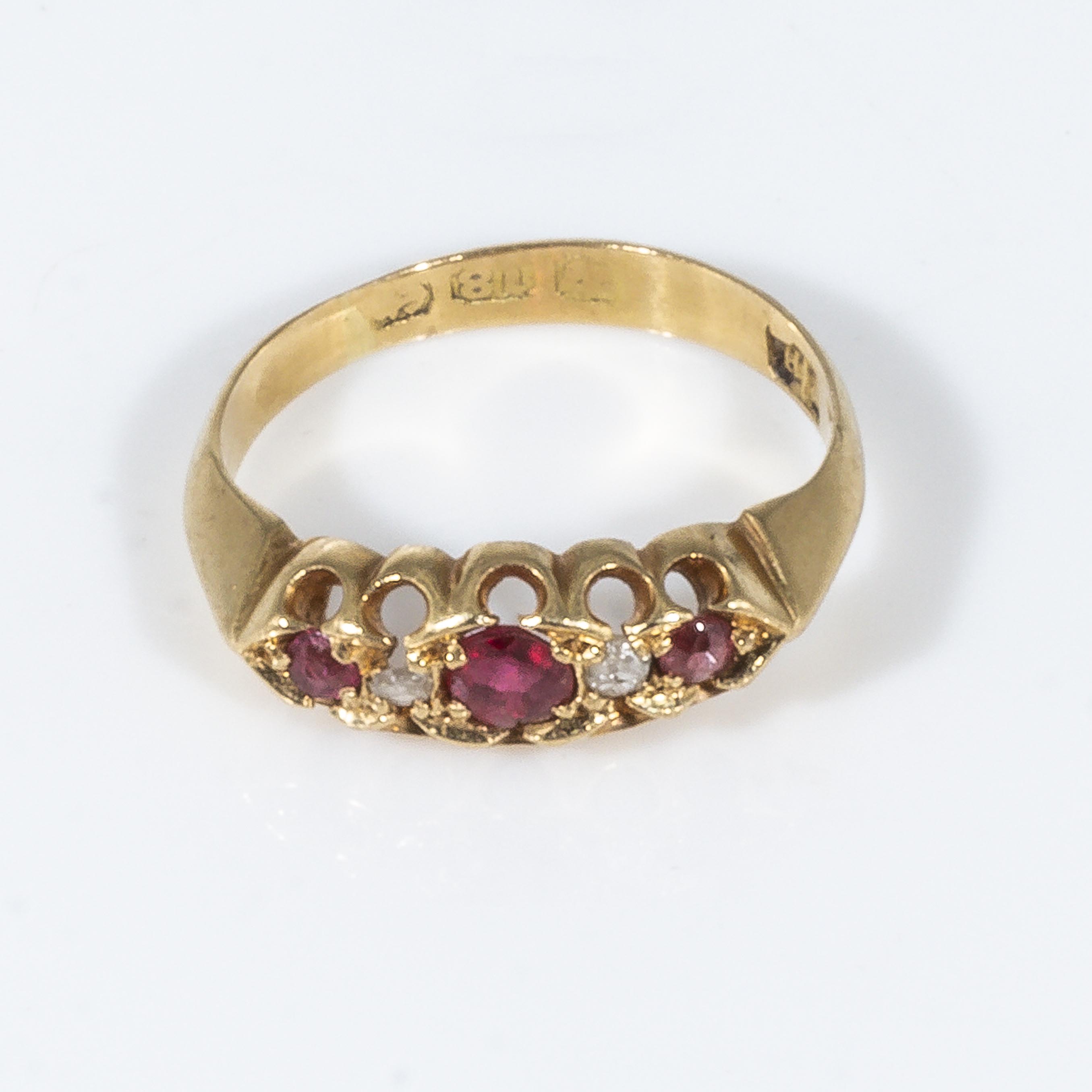 An 18ct gold ring set with three rubies and diamonds, size J