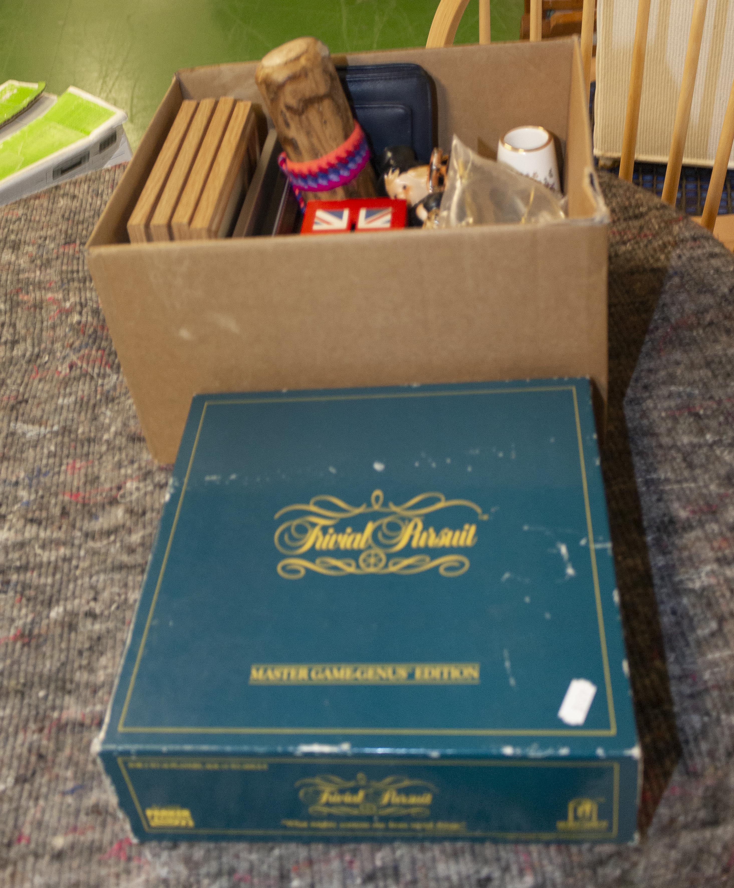 A box of assorted items and a Trivial Pursuit game