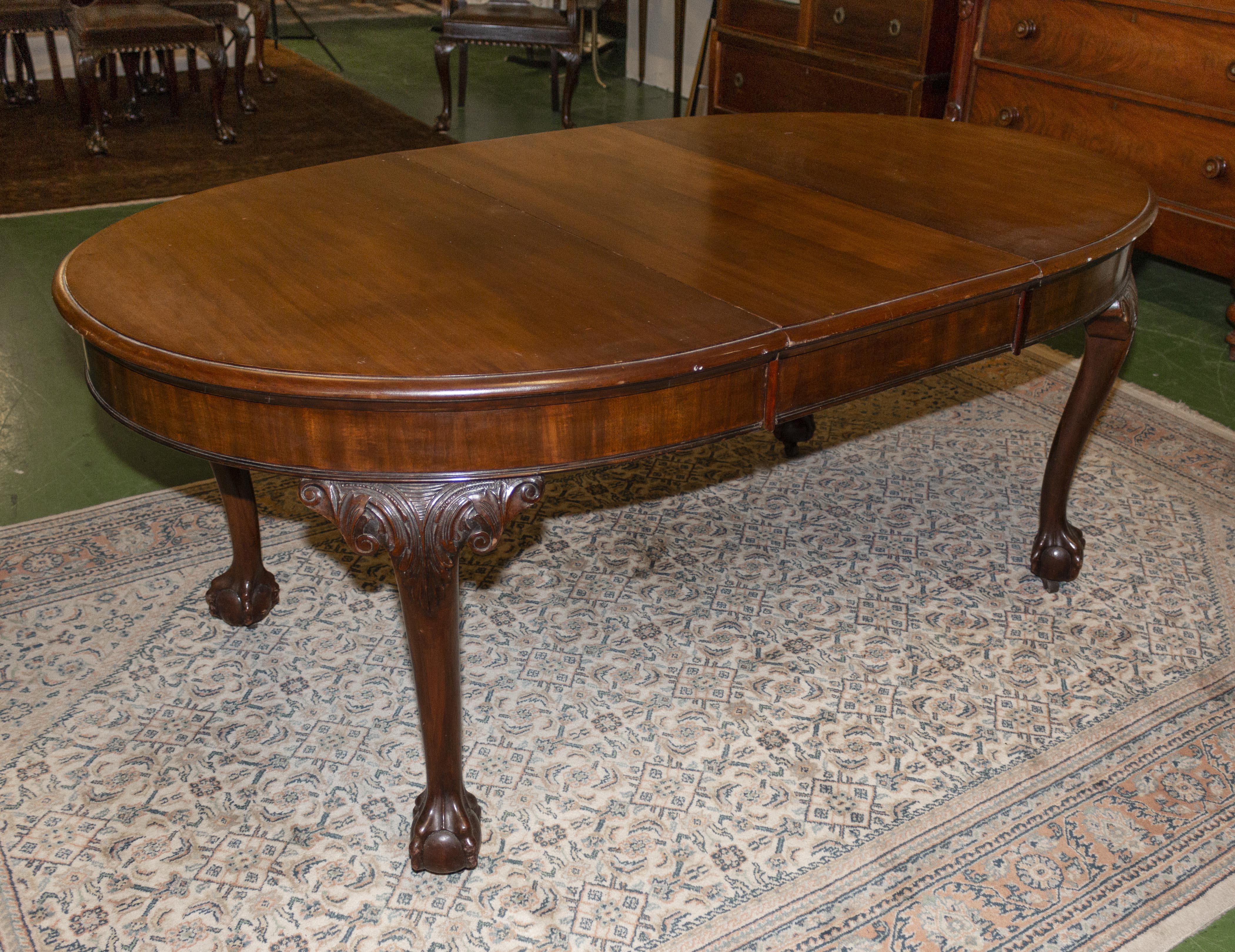 A mahogany extending dining table with one extra leaf