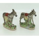 A pair of Staffordshire donkeys carrying baskets of fruit