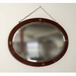 An oval inlaid mahogany mirror