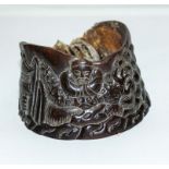 A carved horse hoof depicting a Chinese scene
