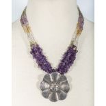 A necklace of amethyst and quartz rough stones with a silver pendant
