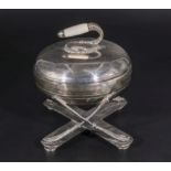 A silver plated butter dish shaped as a curling stone.