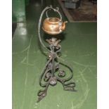 A copper kettle on wrought iron stand
