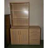 A bookcase on cupboards and a three drawer unit