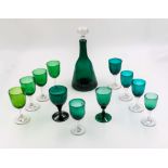 Eleven green wine glasses and a decanter