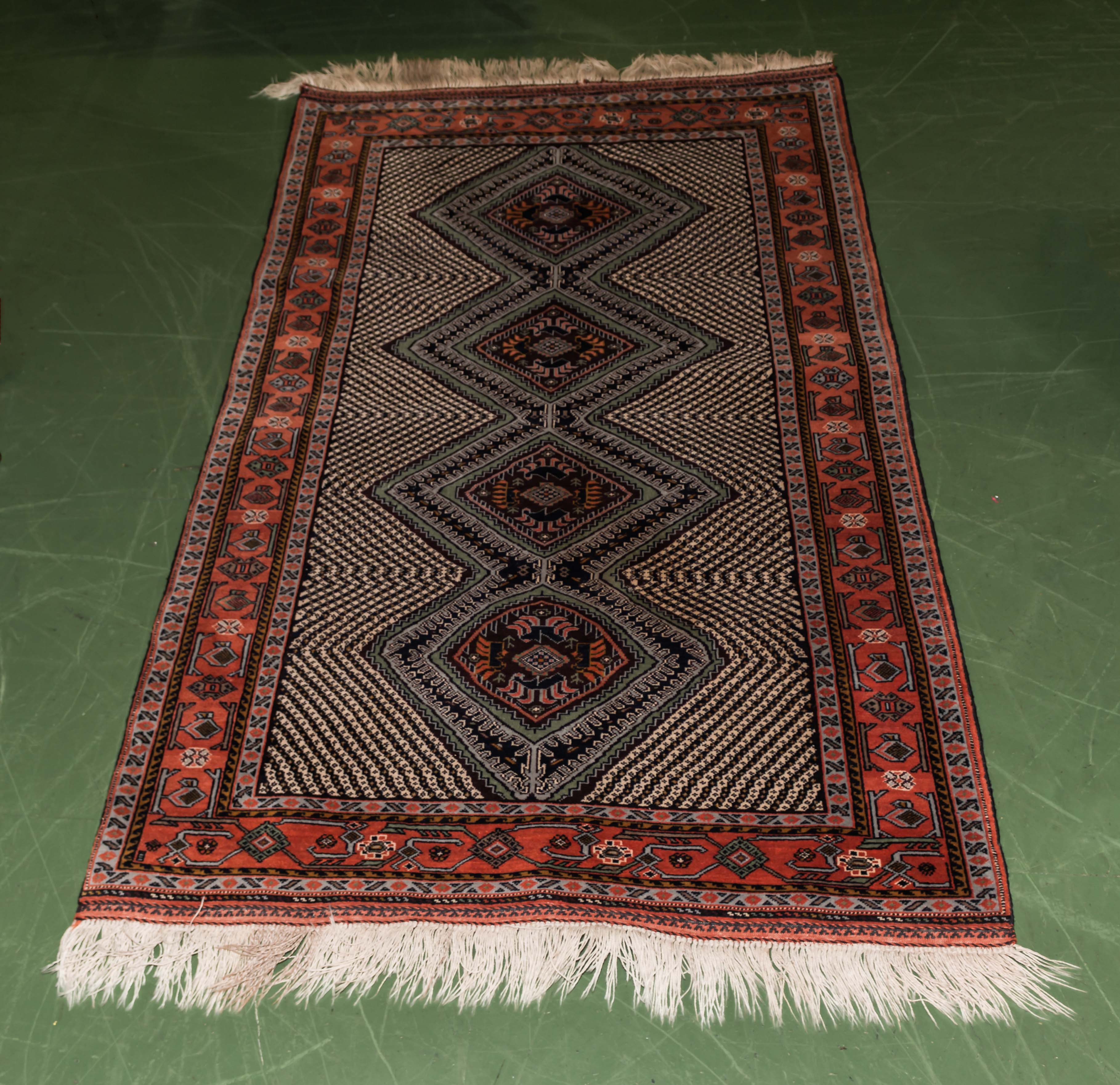 A red ground woollen rug