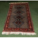 A red ground woollen rug