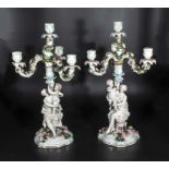 A pair of Dresden style porcelain candelabra, a woman and child holding three branch candelabra with