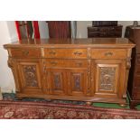 A Victorian carved light oak sideboard