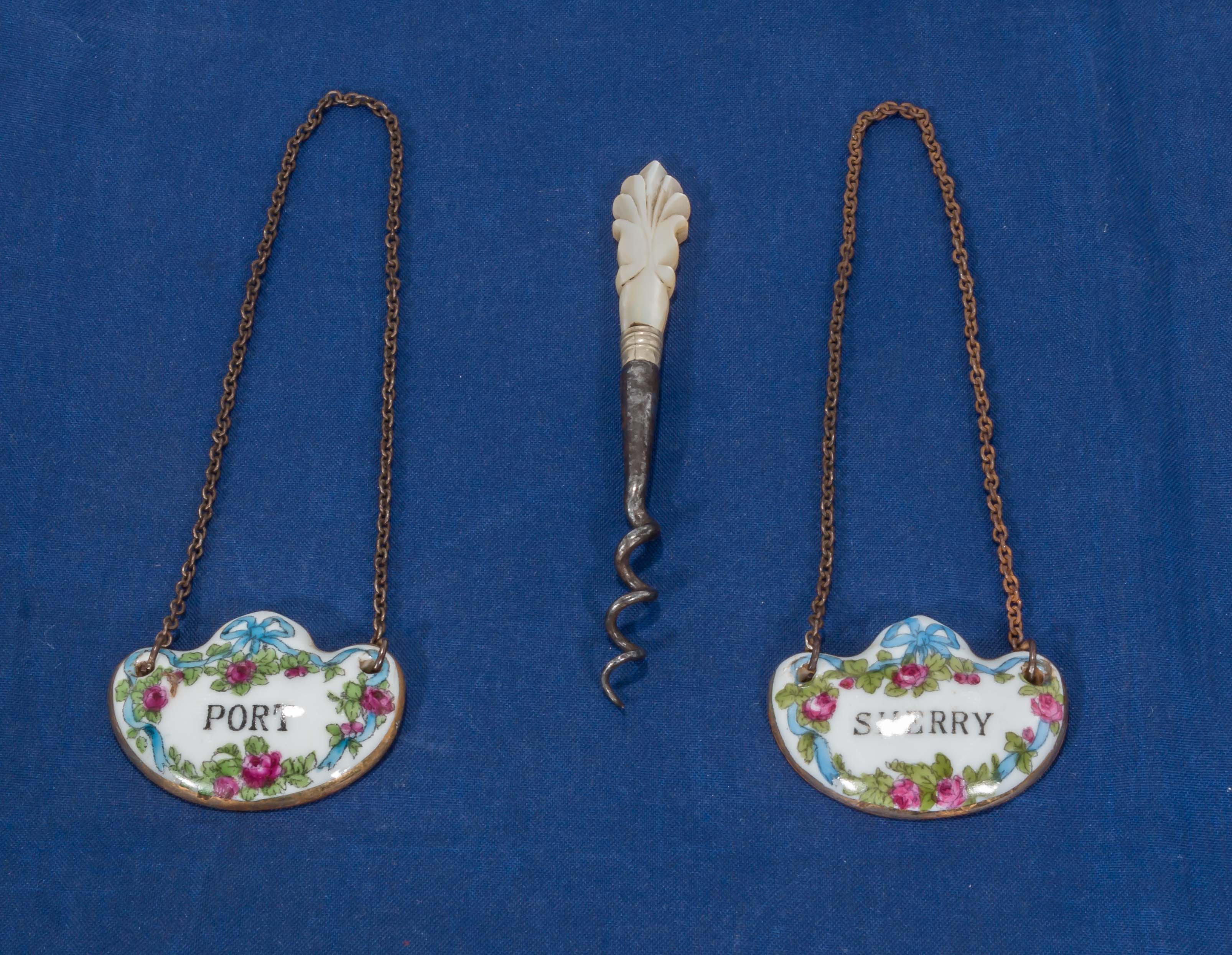 Two porcelain decanter labels and a small corkscrew