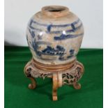 A blue patterned Chinese vase with carved stand