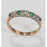 A 9ct gold ring set with four emeralds and three diamonds, size L