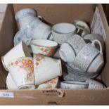 A box containing teacups and saucers