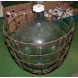 A large carboy in metal carrier