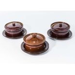 Three small lidded casserole dishes and stands