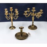Two brass candelabra and a candle stick