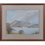 A small framed watercolour depicting a lake and mountain scene, indistinct signature