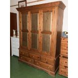 A large pine wardrobe with double drawers and five drawers