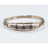 A 9ct gold bangle set with amethyst and peridot