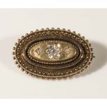 A 15ct gold oval brooch set with 9 diamonds