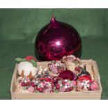 A large Christmas bauble together with a box of Christmas tree decorations