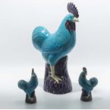 A large Chinese turquoise glazed cockerel together with two smaller ones