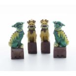 Two pairs of Chinese green and yellow glazed temple dogs