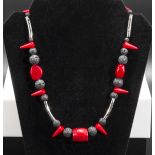 A Unique designer necklace combination of red coral, lava rock and resin with silver tube adornment