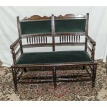 A mahogany two seater settee with green velvet upholstery