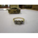 A gold coloured, three stone diamond ring in a claw setting