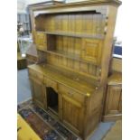 A reproduction English oak dresser having a plate rack above with drawers and cupboards below, 72" h