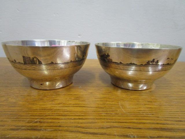 A pair of Iranian white metal bowls with Niello decoration of boats in a coastal scene, 111g