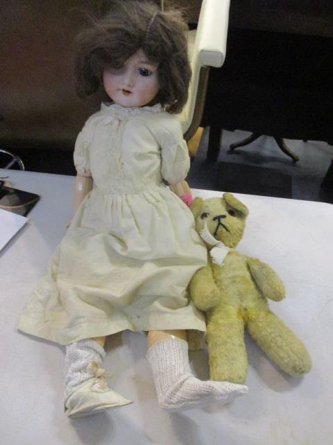 An early 20th century Armand Marseilles doll and a stuffed bear