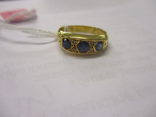 An early 20th century 18ct gold three stone sapphire and diamond chip ring - Image 2 of 2