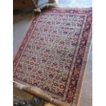 A machine woven beige and red ground rug having floral designs and multiguard borders, 66" x 47"