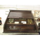 An early 20th century optician's oak cabinet with a tambour front, enclosing a removable tray with