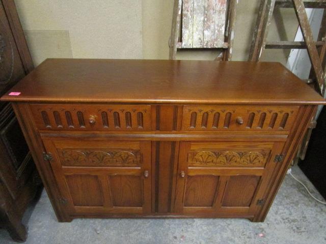 A mid 20th century light oak sideboard with two short drawers over twin cupboard doors