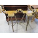 A pair of high stools having wrought iron supports and block shaped legs, 36" x 10"