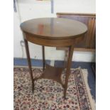 An Edwardian mahogany two tier circular topped occasional table, on four string inlaid, tapering