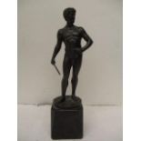 An early 20th century cast bronze figure of a man wearing a loincloth, holding a batton, stamped