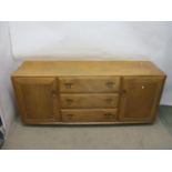 An Ercol elm Windsor, Golden Dawn, sideboard with three drawers flanked by a pair of doors, on