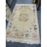 A Chinese cream ground rug having a central medallion and border decorated with fish and foliage,